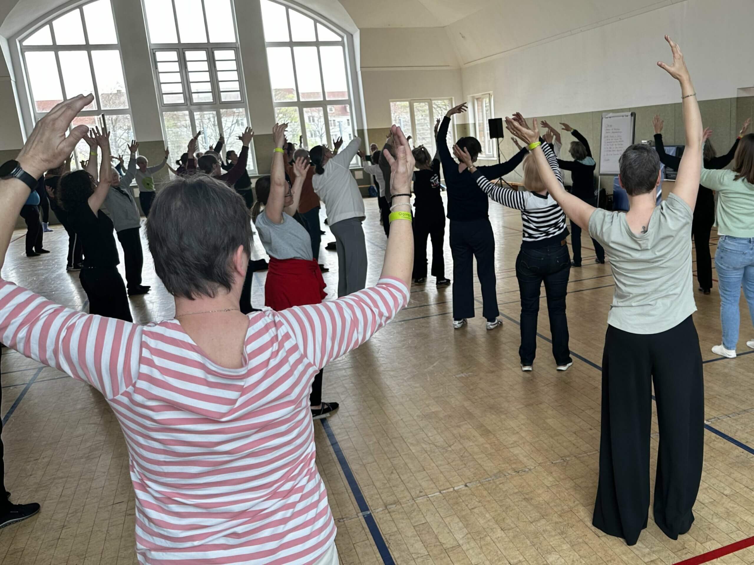 Gruppe hebt Arme in einer Qigong-Übung