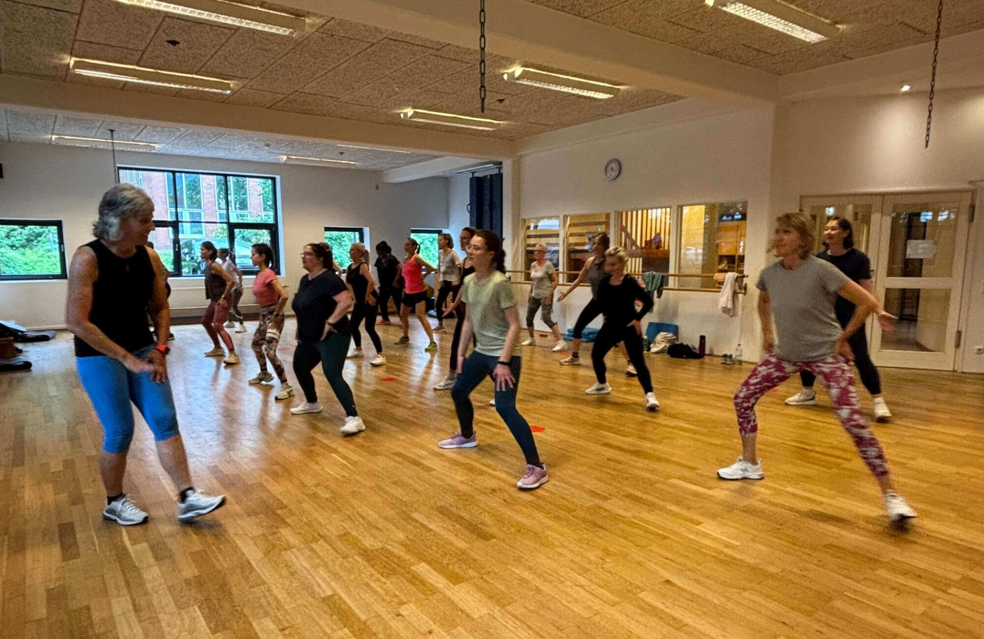 Referentin vor GroupFitness Gruppe in Aerobic-Schritt