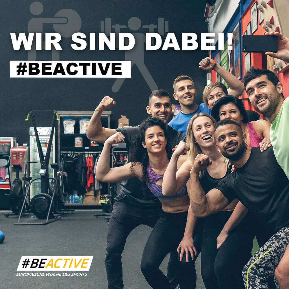 Wir sind dabei #BeActive - Eine Gruppe an Fitnesssportler*innen zeigt ihre Muskeln im Hintergrund sind Fitnessgeräte zu sehen