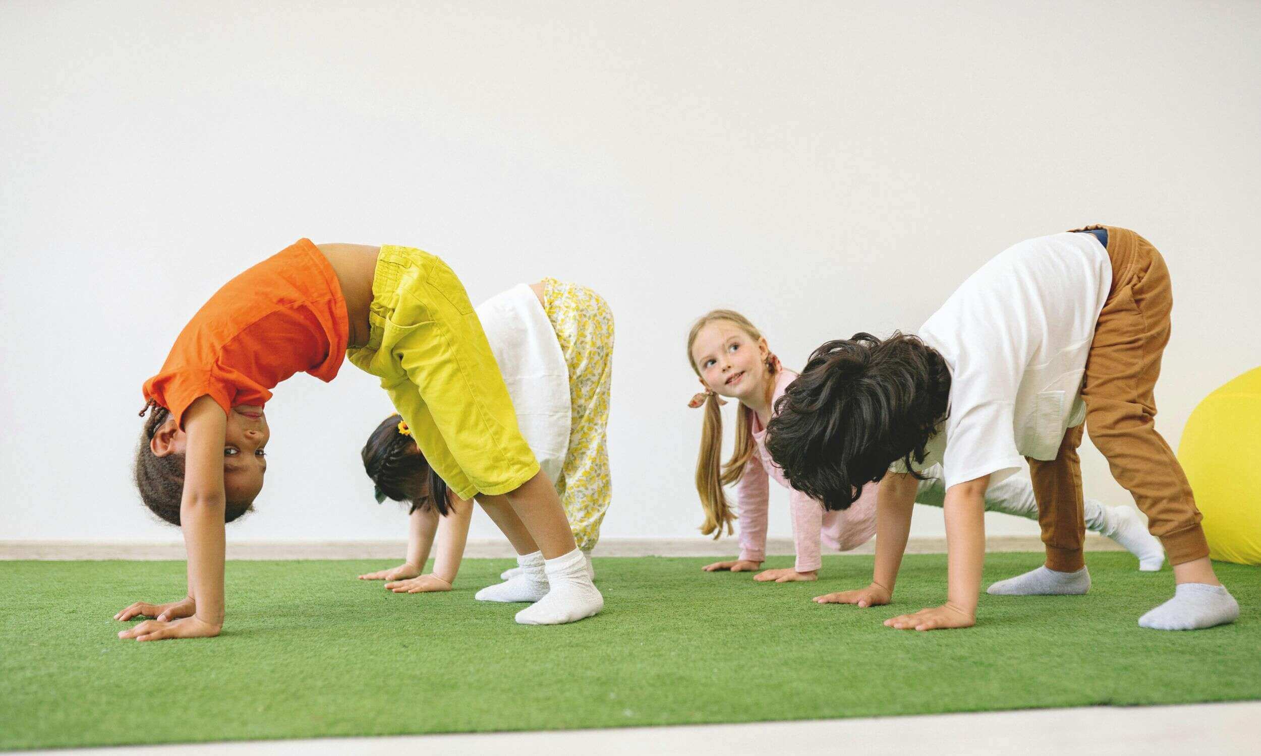 Kinder krabbeln auf einem grünen Untergrund