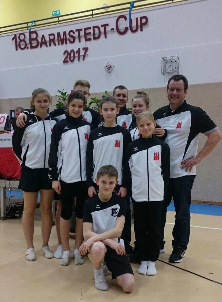 Olaf SChmidt 2018 im Kreise von 8 jugendlichen Sportler*innen im schwarz weißen Trainingsanzug des Bramfelder SV