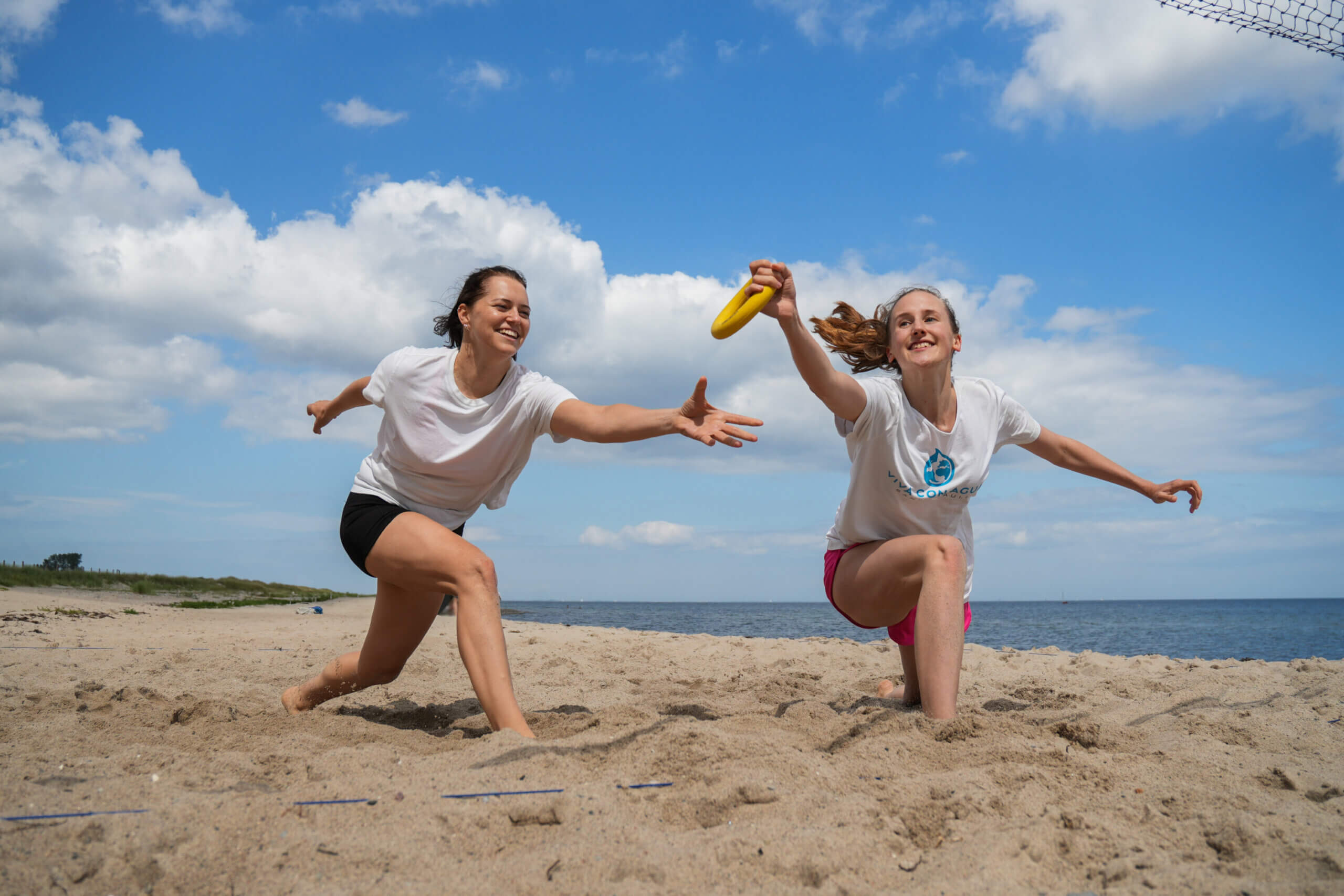 Zwei Frauen spielen Ringtennis am Meer.