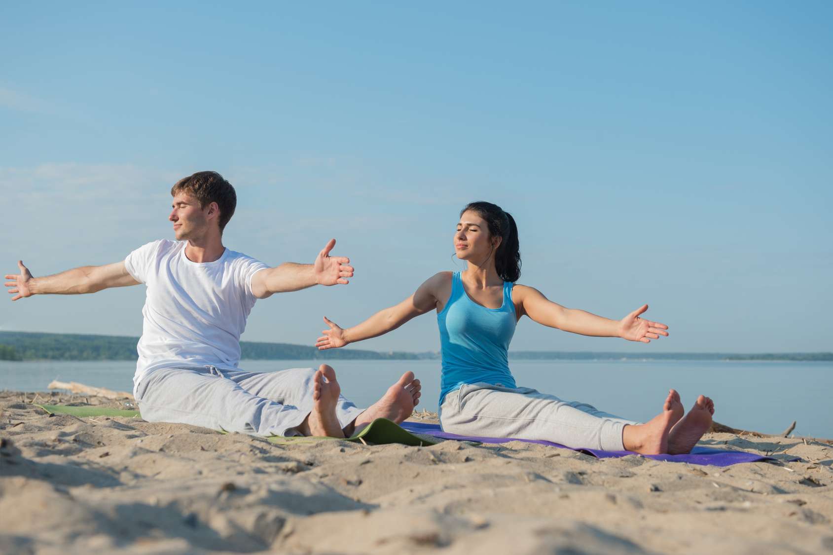 Paar, 30 Jahre, macht Yoga am Strand