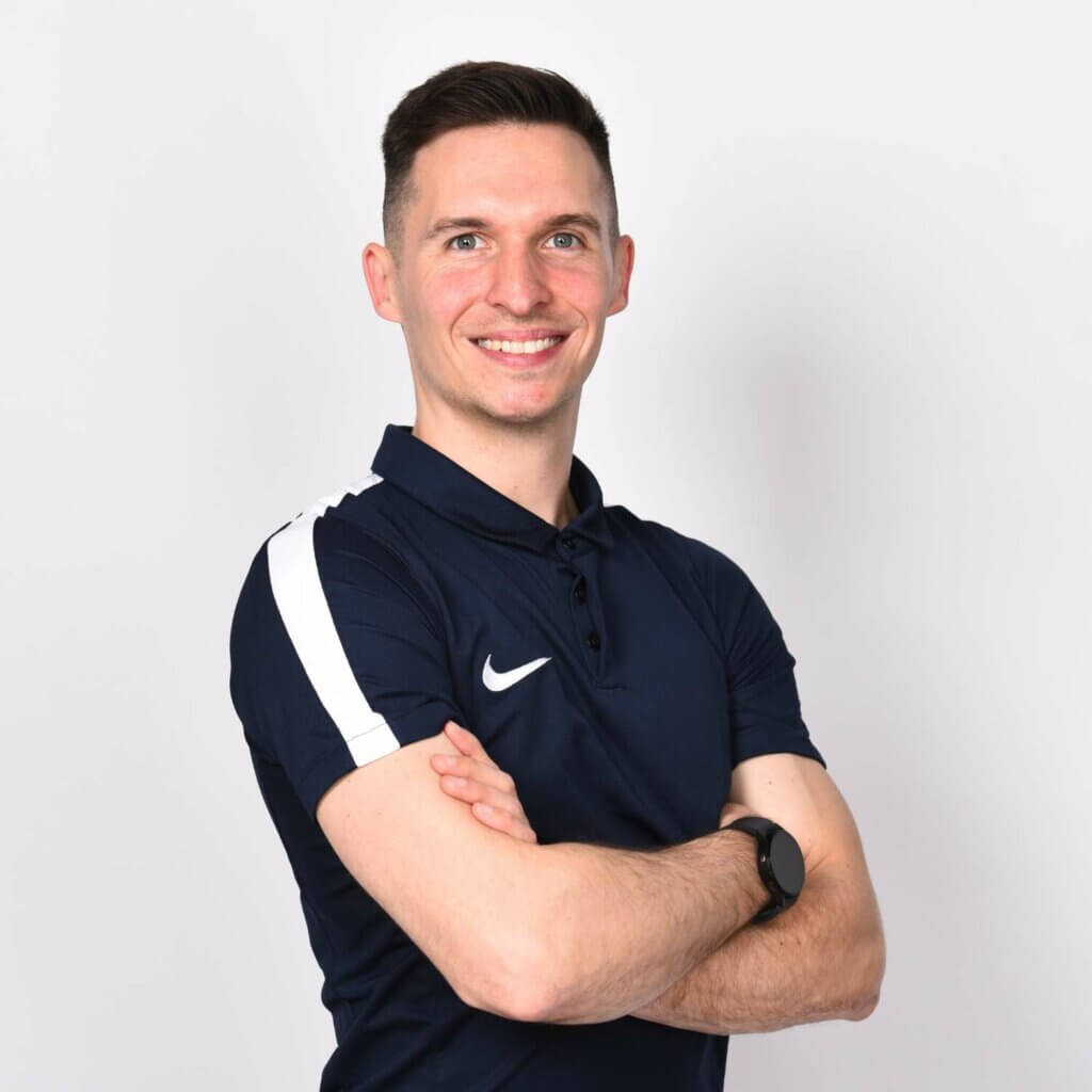 junger Mann in Sporttrikot überkreuzt die Arme