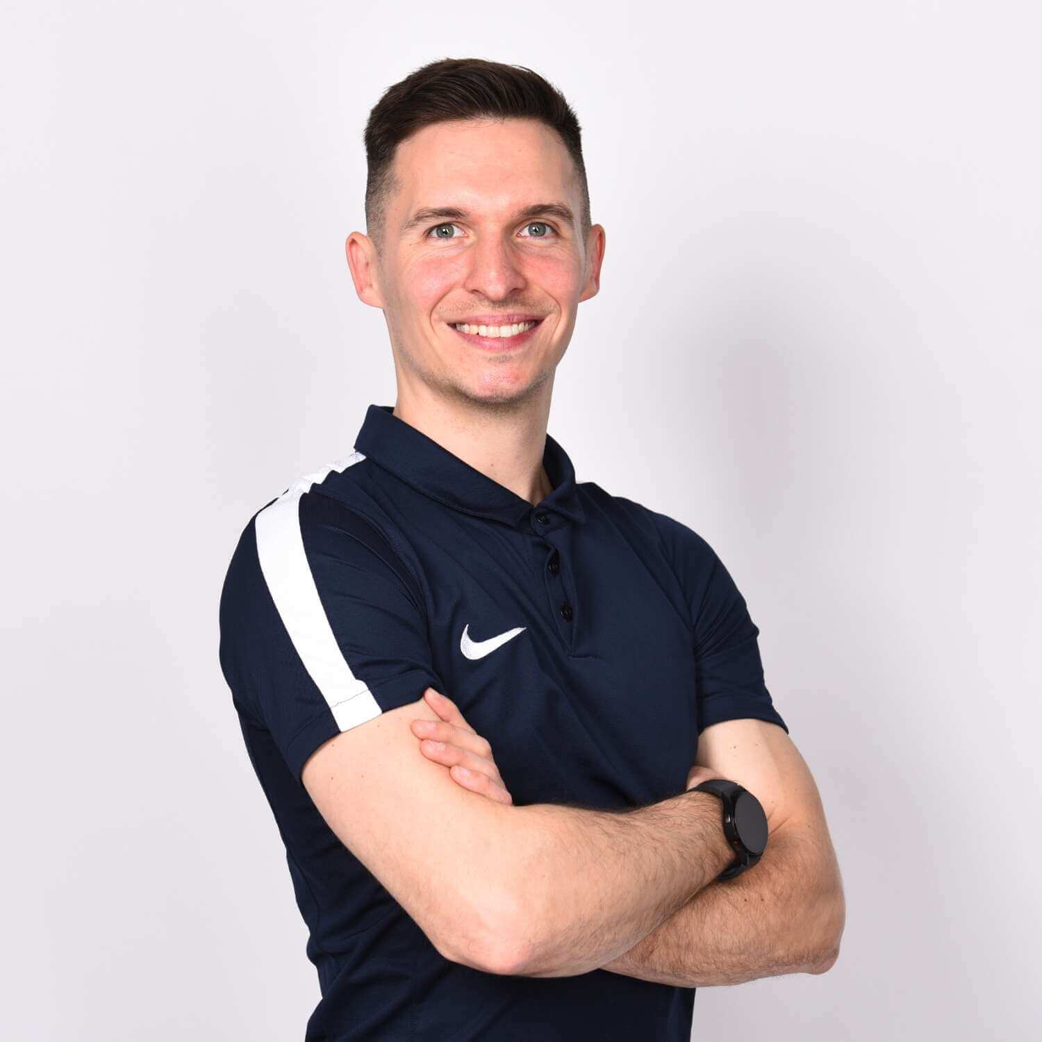 junger Mann in Sporttrikot überkreuzt die Arme