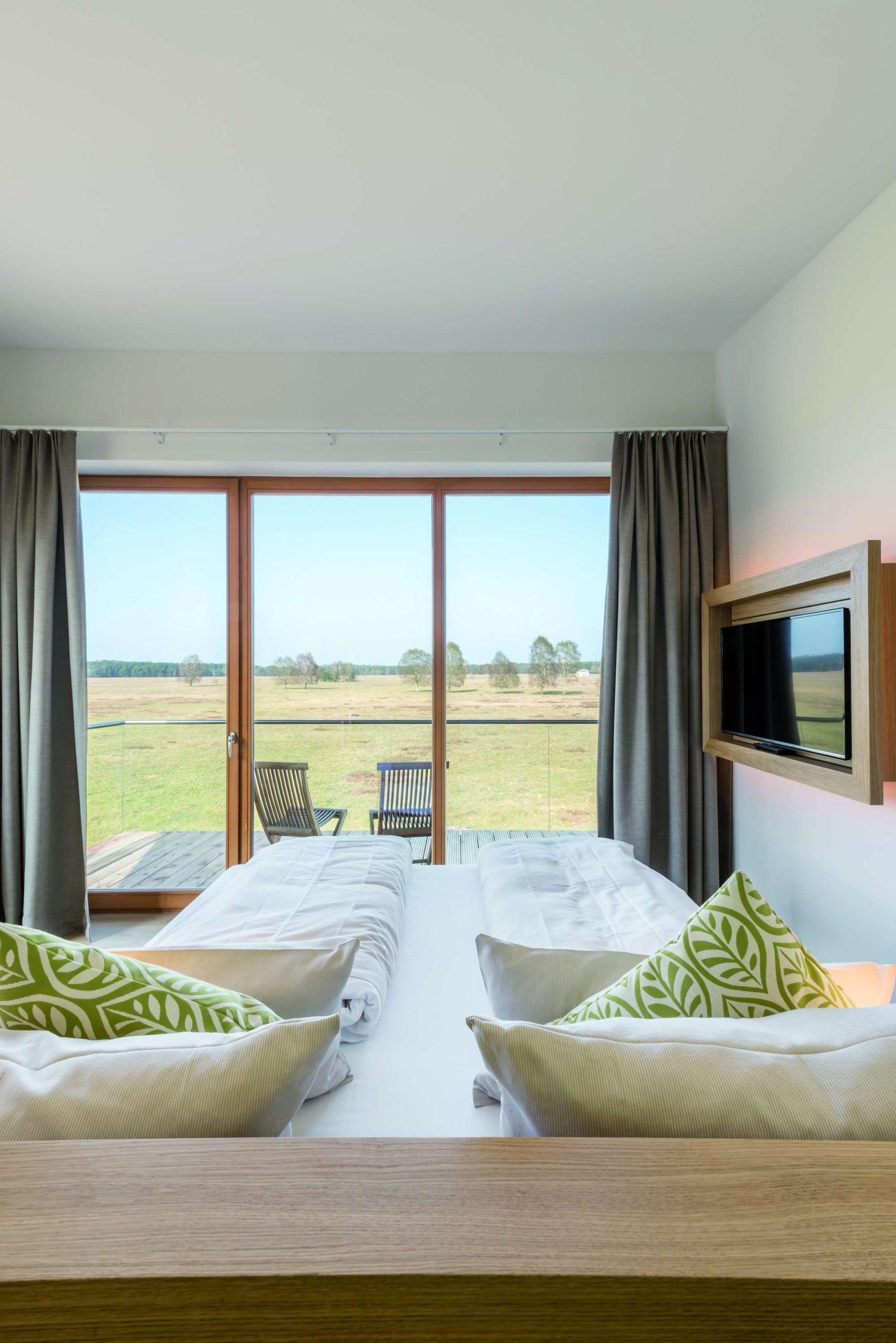 Hotelcamp Reinsehlen Zimmer mit Doppelbett und Blick aus dem Fenster auf die Heide