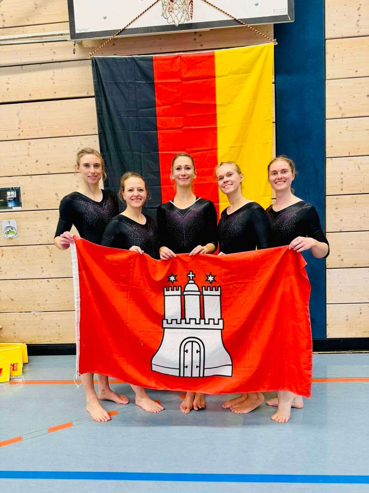 Julia Konrad, Laura Kaltenberg, Alexandra Schormann, Annika Studt und Anna Geils posieren mit der Flagge Hamburgs vor der Deutschlandflagge