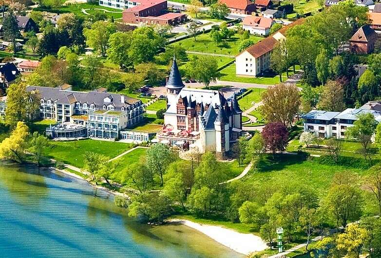 Seehotel Schloss Klink Luftaufnahme vom Hotel und Orangerie mit Hafen, Strand und Steg