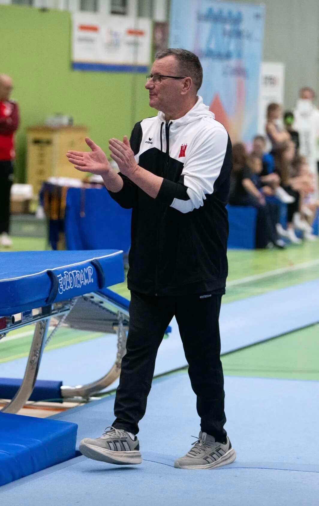 Olaf Schmidt in Sportkleidung geht und klatscht in die Hände