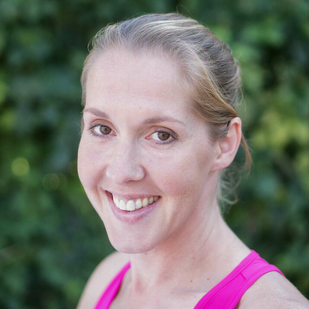 Elena Breyer lächelnd vor einem grauen Hintergrund