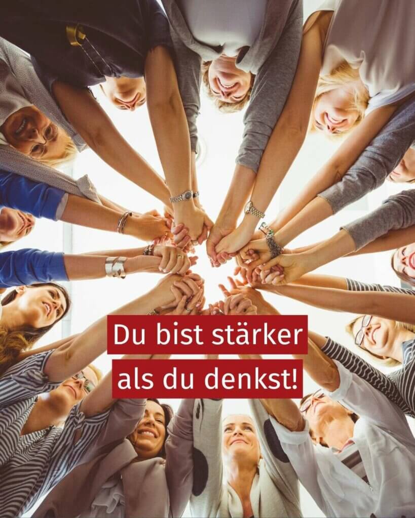 Eine Gruppe von Feauen stehen in einem Kreis zusammen und strecken die Arme sternartig in die Mitte, das Foto ist von unten aufgenommen, man siehr nur einen Teil der Oberkörper und die in die Mitte gestreckten Arme