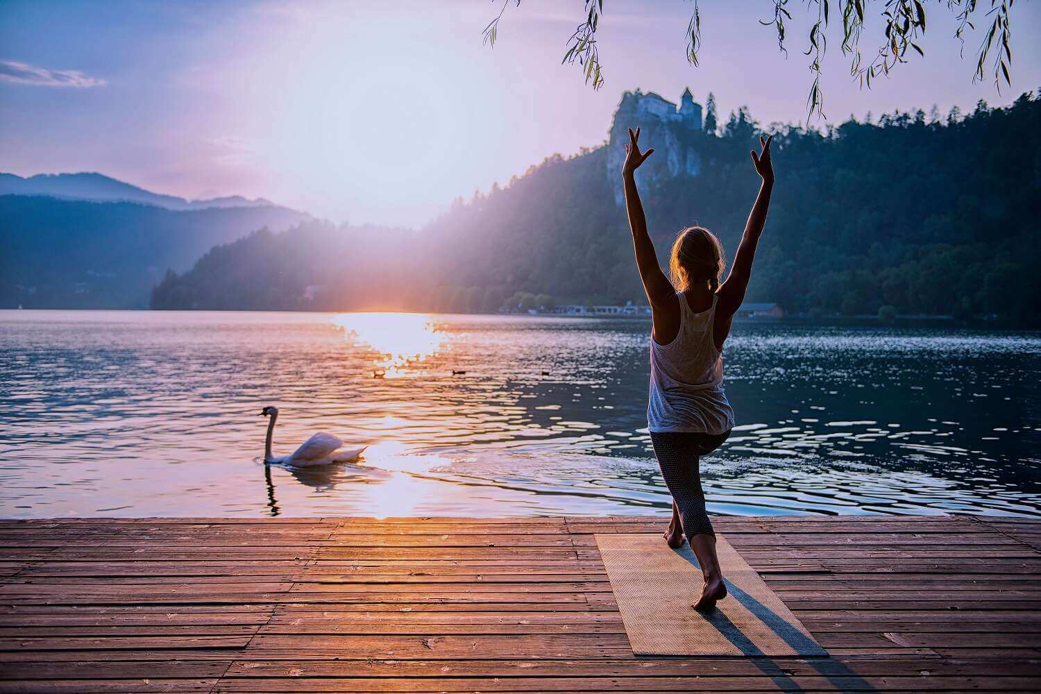 Frau macht Yoga auf Holzsteg am Bergsee