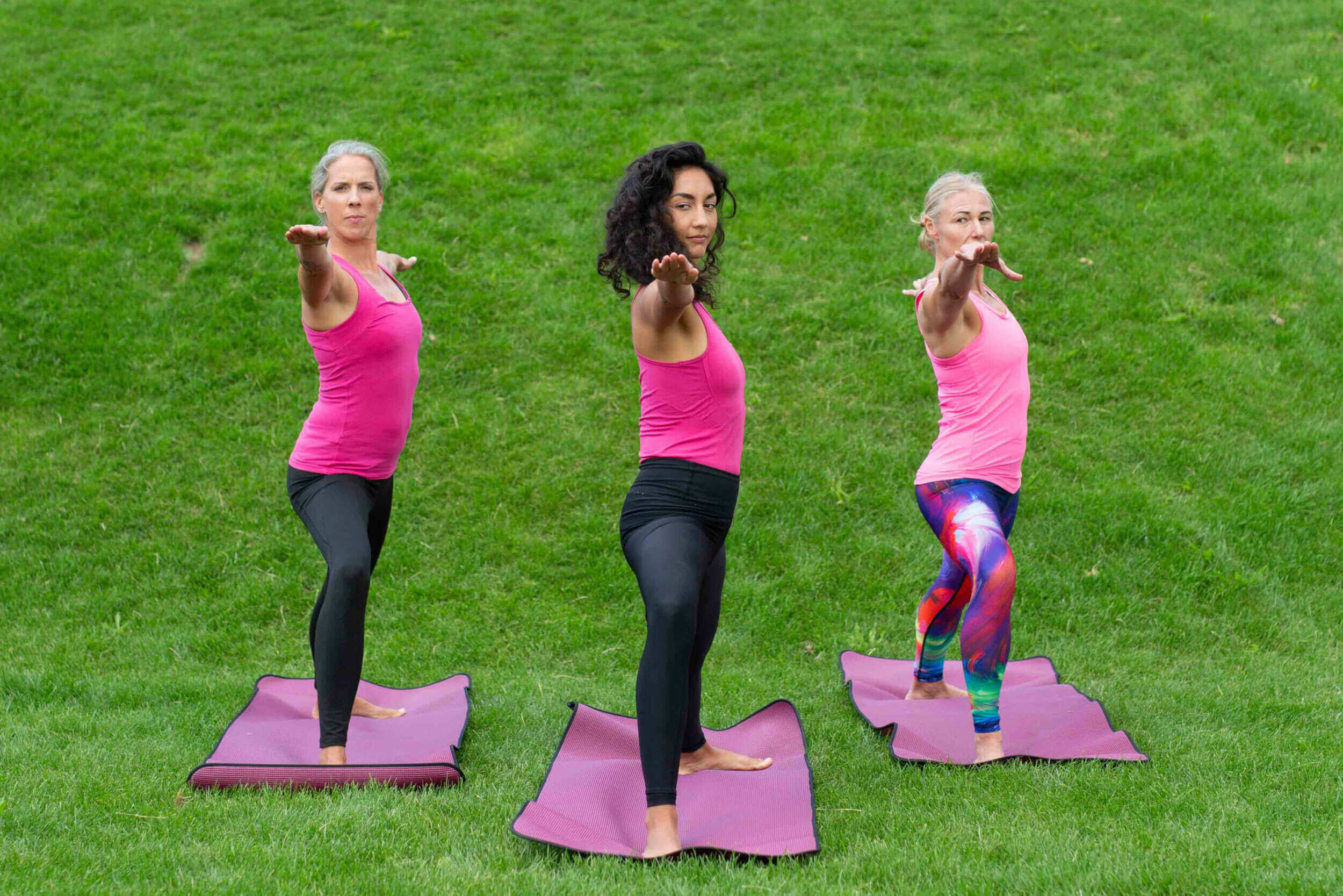 Drei Frauen in der Yoga Position Krieger.